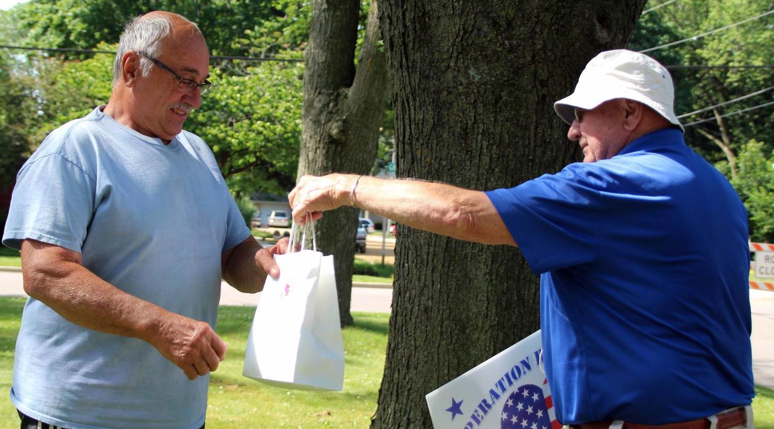 Dave hands Richard gift